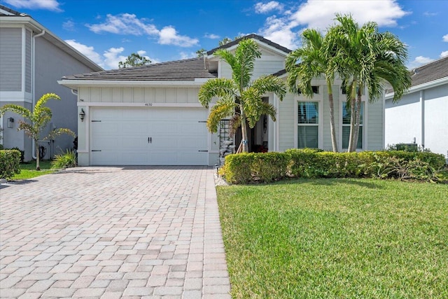 view of front of property featuring a front lawn and a garage