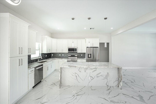 kitchen featuring white cabinetry, a kitchen island, stainless steel appliances, and pendant lighting