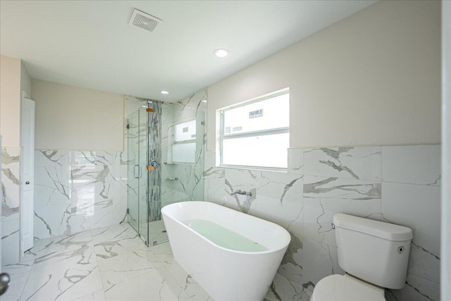 bathroom featuring tile walls, shower with separate bathtub, and toilet