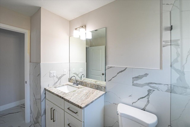 bathroom with tile walls, vanity, and toilet