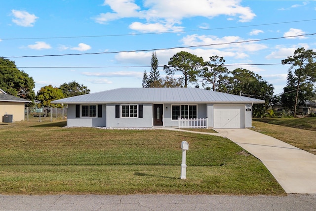 ranch-style home with a garage, cooling unit, and a front lawn