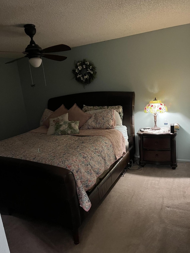 bedroom featuring a textured ceiling, carpet floors, and ceiling fan