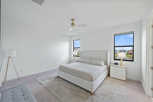 bedroom featuring a ceiling fan, light carpet, visible vents, and baseboards