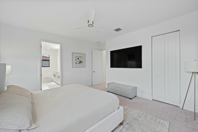 bedroom featuring ceiling fan, ensuite bathroom, light colored carpet, visible vents, and a closet