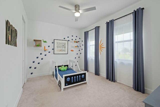 bedroom featuring light colored carpet, ceiling fan, and baseboards