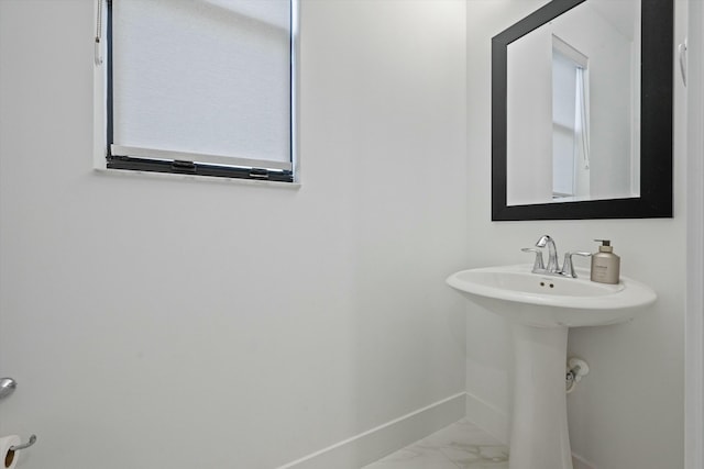 bathroom featuring marble finish floor and baseboards