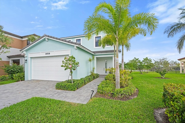 view of front of property with an attached garage, a front lawn, decorative driveway, and stucco siding