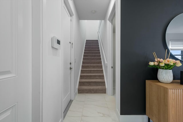 hall featuring marble finish floor and stairway