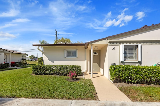 view of front of house featuring a front lawn and stucco siding