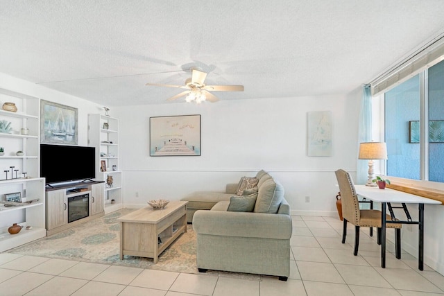 living area with a textured ceiling, light tile patterned floors, a ceiling fan, and built in features