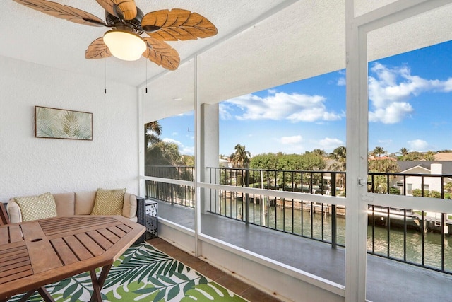 balcony featuring ceiling fan and a water view