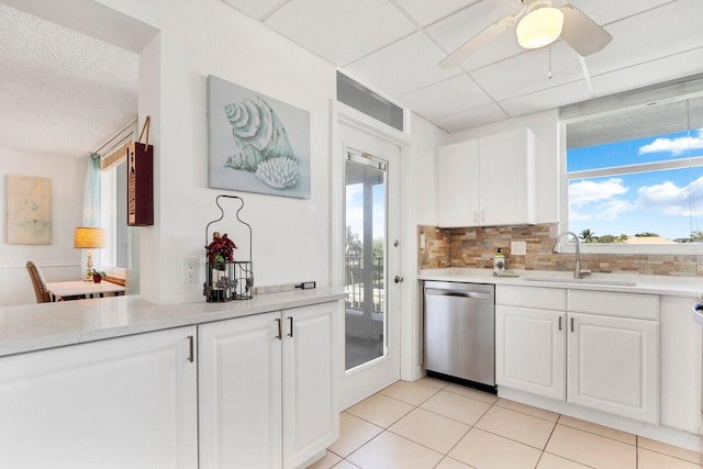 kitchen featuring light countertops, dishwasher, a sink, and white cabinetry