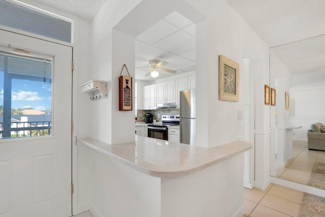 kitchen with electric range, freestanding refrigerator, white cabinetry, a peninsula, and under cabinet range hood