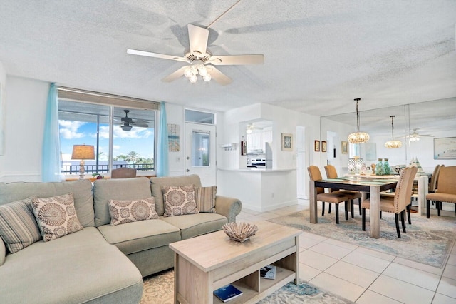 living area with light tile patterned floors, a textured ceiling, and ceiling fan with notable chandelier