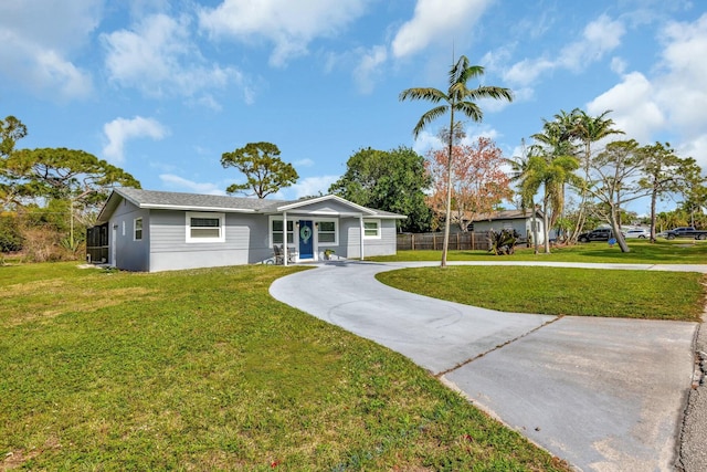 single story home featuring concrete driveway, a front yard, and fence