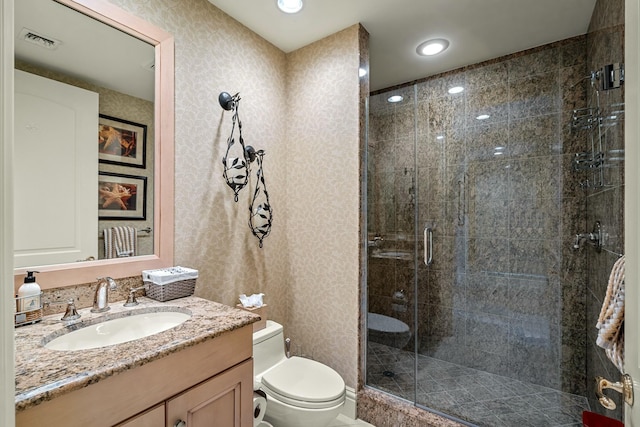 bathroom featuring toilet, a stall shower, recessed lighting, vanity, and wallpapered walls