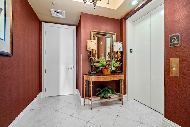 foyer featuring elevator and baseboards