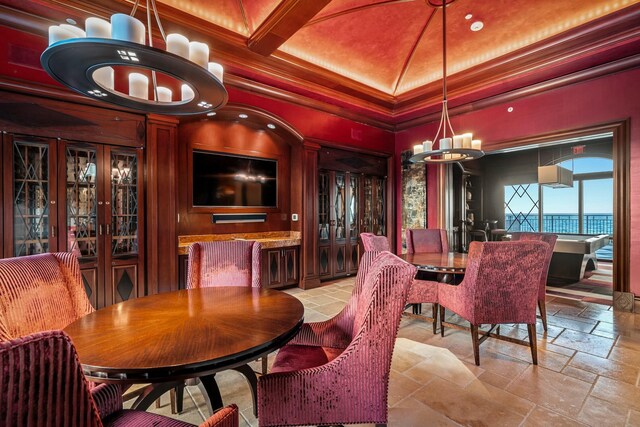 dining space featuring stone tile floors, a chandelier, ornamental molding, coffered ceiling, and beam ceiling