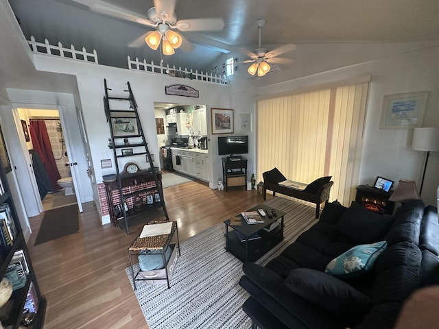 living room featuring ceiling fan, wood-type flooring, and lofted ceiling