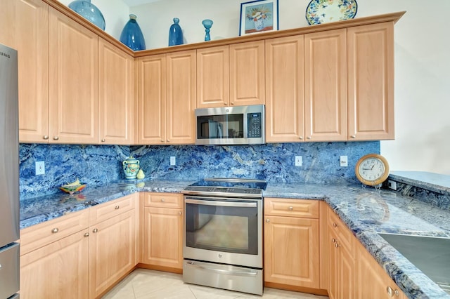 kitchen with light tile patterned floors, stainless steel appliances, stone counters, and light brown cabinets