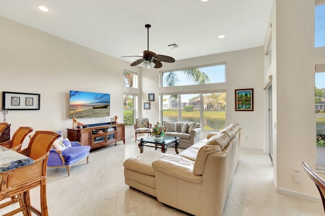 living area featuring recessed lighting, visible vents, a high ceiling, ceiling fan, and baseboards