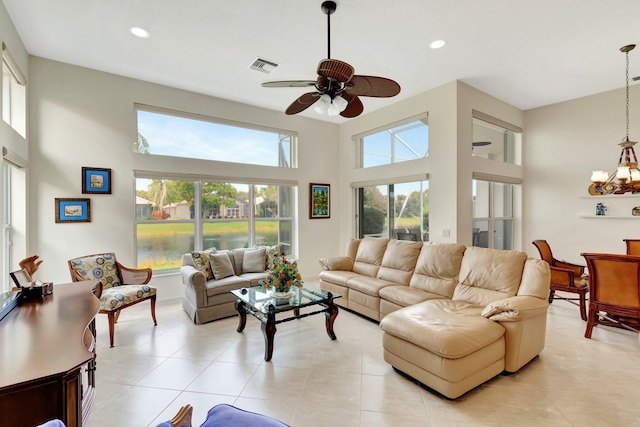 living room featuring light tile patterned floors, a high ceiling, visible vents, and recessed lighting