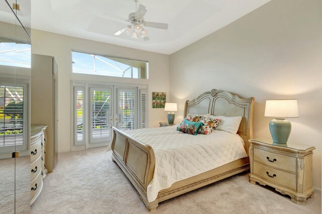 bedroom featuring light carpet, french doors, a ceiling fan, and access to exterior