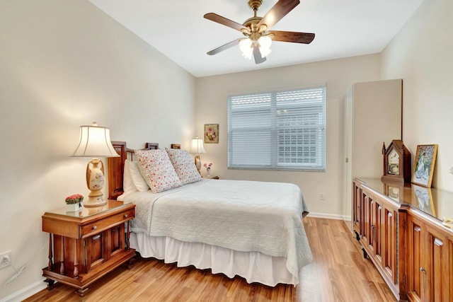 bedroom with light wood-style floors, ceiling fan, and baseboards