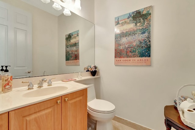 half bath with a chandelier, vanity, and toilet