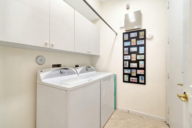 washroom with cabinet space, baseboards, and washer and clothes dryer