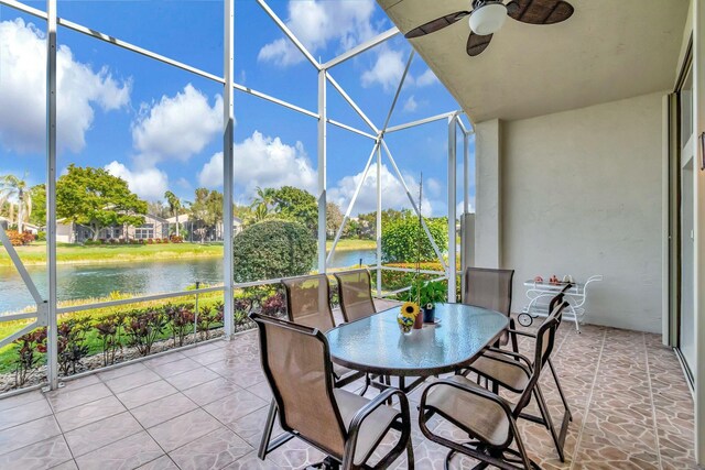 sunroom / solarium with a water view and ceiling fan