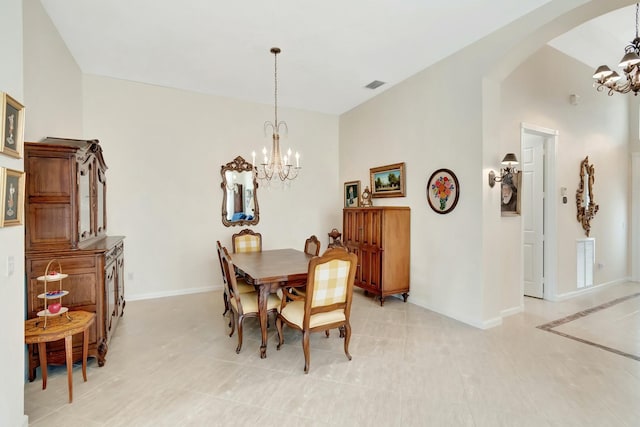 dining area featuring an inviting chandelier, visible vents, arched walkways, and baseboards