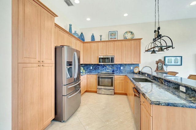 kitchen featuring light brown cabinets, a peninsula, a sink, visible vents, and appliances with stainless steel finishes