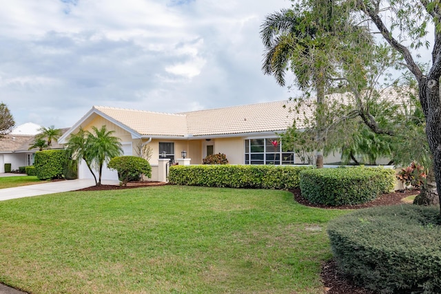 ranch-style home featuring a front lawn, driveway, a tiled roof, and an attached garage