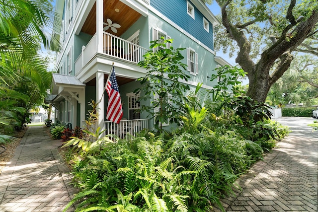 view of home's exterior with a balcony and ceiling fan