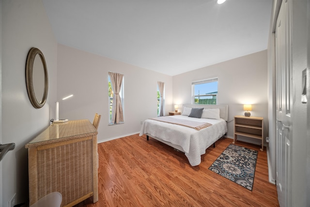 bedroom featuring light wood finished floors and baseboards