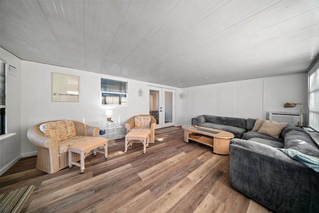 living room featuring a wall mounted air conditioner, wood finished floors, and french doors