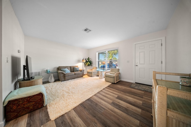 living area featuring dark wood-style floors, baseboards, and visible vents