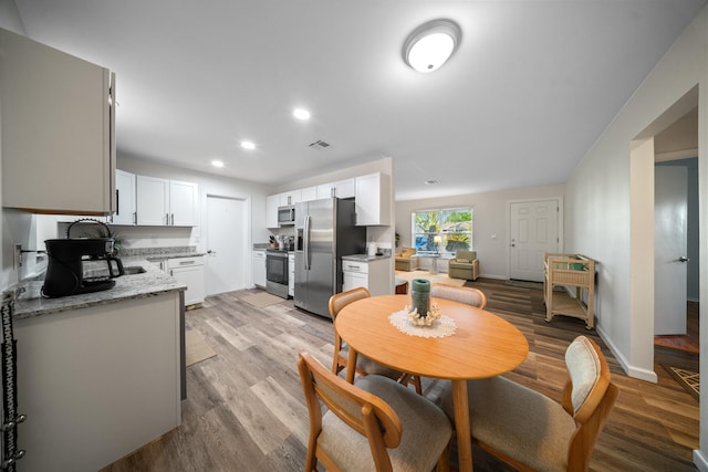 dining room with recessed lighting, baseboards, visible vents, and light wood finished floors