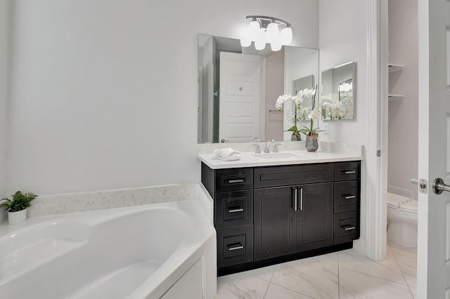 full bathroom featuring toilet, a garden tub, marble finish floor, and vanity