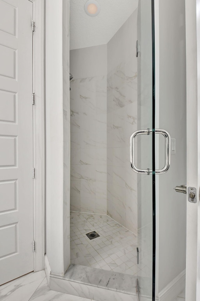 full bathroom with marble finish floor and a marble finish shower