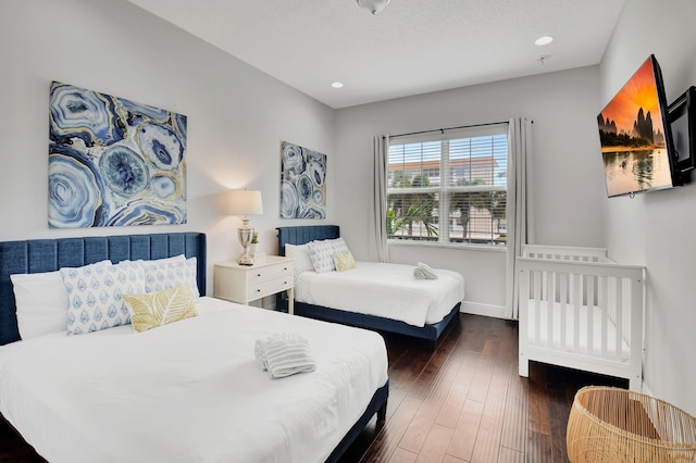 bedroom featuring baseboards, dark wood-style flooring, a textured ceiling, and recessed lighting