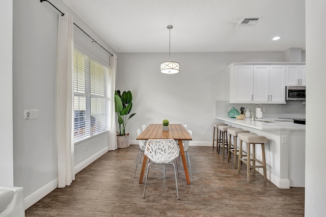 dining room featuring visible vents, baseboards, dark wood-style flooring, and recessed lighting