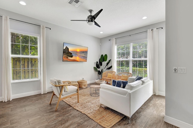 living room with recessed lighting, visible vents, a ceiling fan, wood finished floors, and baseboards