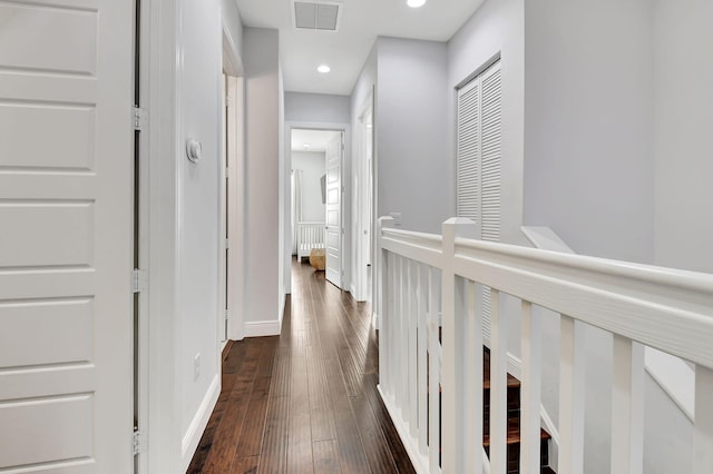 hall featuring dark wood finished floors, recessed lighting, visible vents, an upstairs landing, and baseboards