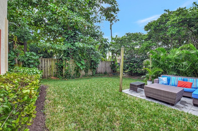 view of yard with a fenced backyard, a patio, and an outdoor living space