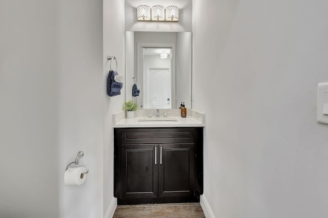 half bathroom featuring vanity and baseboards