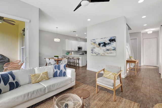 living area with ceiling fan, baseboards, dark wood finished floors, and recessed lighting