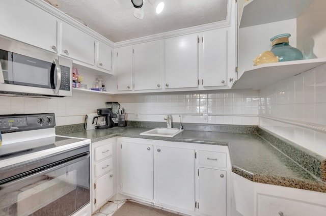 kitchen with black / electric stove, stainless steel microwave, a sink, and white cabinets