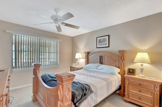 bedroom with light carpet, a textured ceiling, a ceiling fan, and baseboards